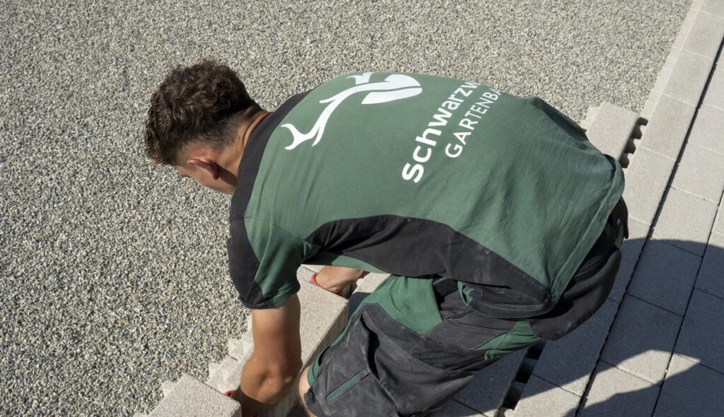 Mitarbeiter von oben gesehen beim Verlegen von Wegeplatten