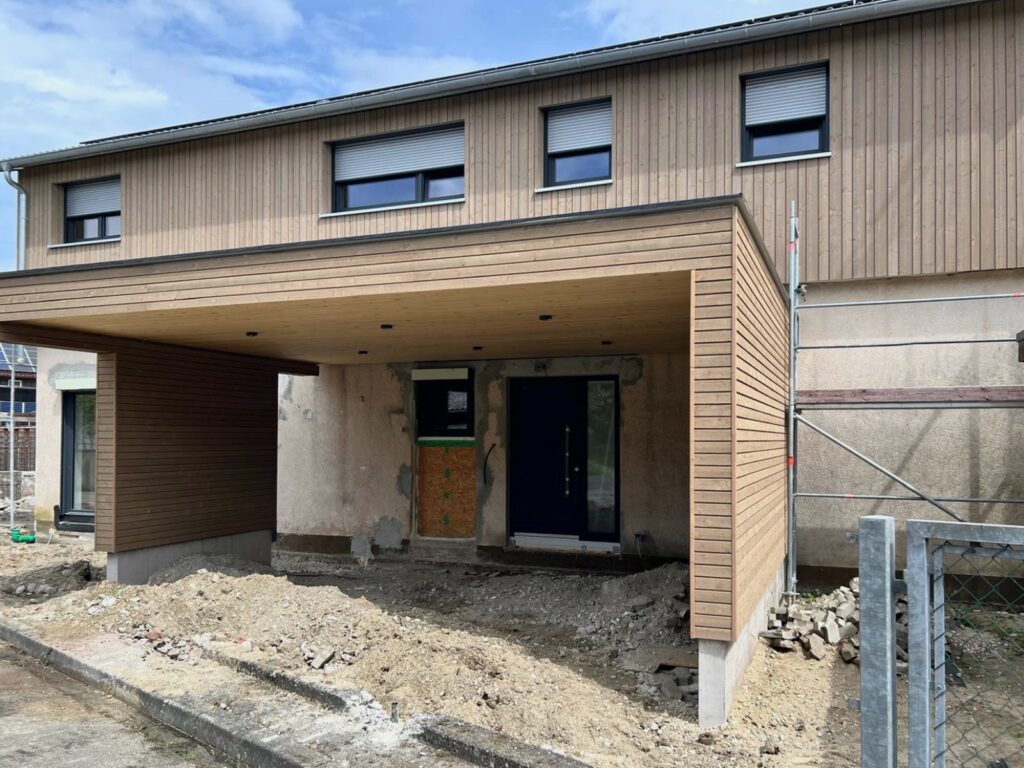 Vorher: Neubau mit Carport, davor offener Baugrund mit Schutt
