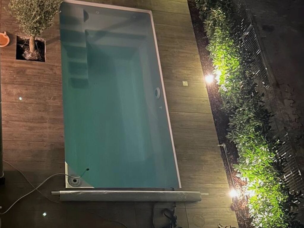 Nachher: Beleuchteter Pool im Innenhof bei Nacht, von oben