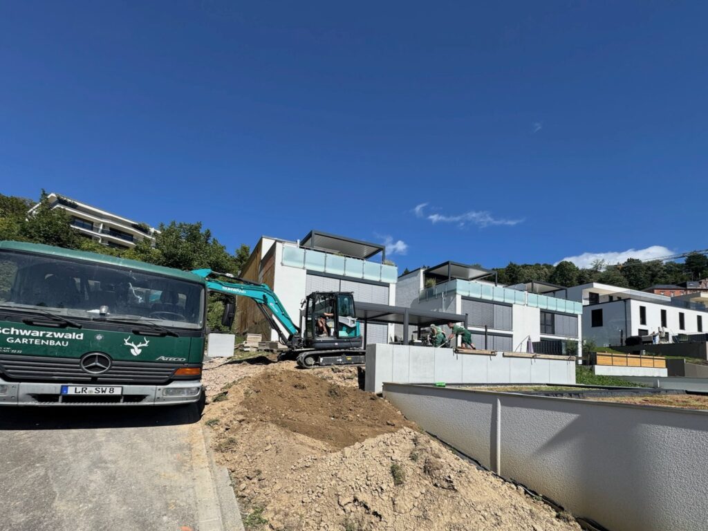 Vorher: Hanggrundstück mit Erdaushub, Bagger und Firmen-LKW